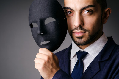 Elegancki mężczyzna trzymający w ręku czarną maskę