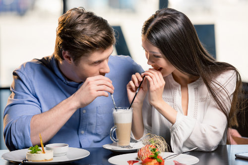 Kobieta i mężczyzna uśmiechnięci przy stoliku w kawiarni