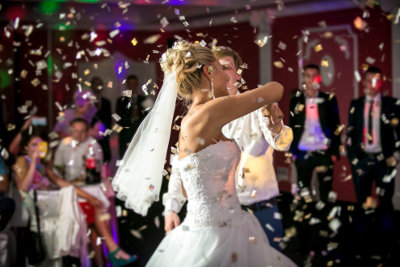 Dziewczyna w sukni ślubnej tańczy na sali weselnej